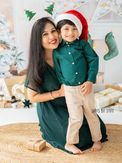 A classic mother-son portrait in front of the Christmas tree. Their smiles and festive attire capture the happy spirit of the season.