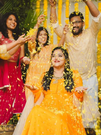 Friends and family showering the bride-to-be with flower petals. Our vibrant marigold backdrop makes these candid moments even more colorful and memorable.