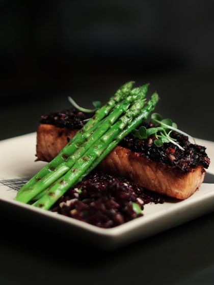 Indulge in the flawless sear of our salmon, served with a savory black bean sauce and captivating black rice. This is our vision of elevated indulgence.