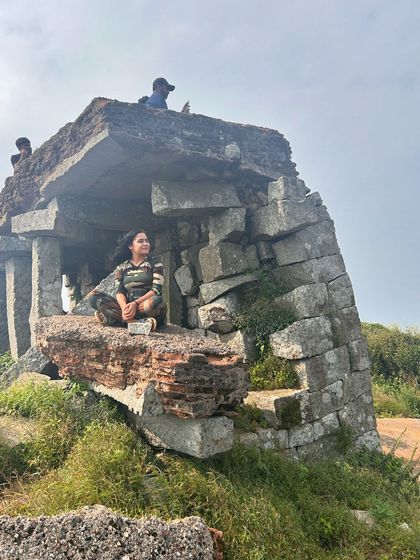 Posing inside the stone structure ruins at the top of Skandagiri.