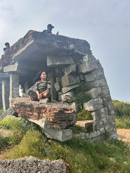 Posing inside the stone structure ruins at the top of Skandagiri.