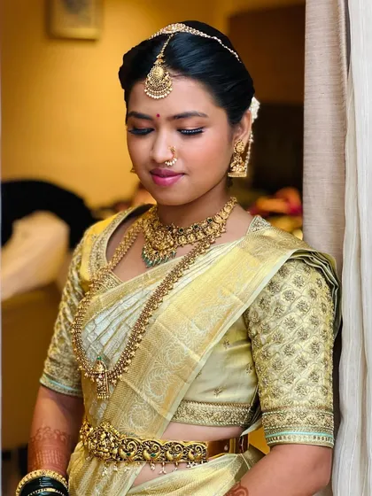 Another portrait of the bride in her light gold saree, showing the beautiful fit of the custom blouse and how it complements her traditional gold jewelry.