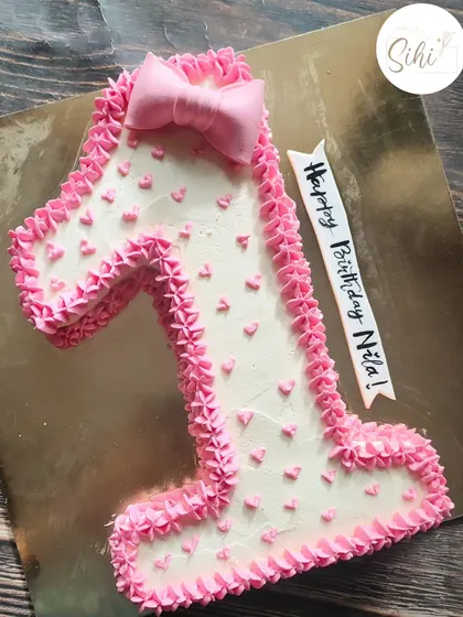 Another view of the adorable number one cake for Nila's first birthday celebration. The piped details and tiny hearts make it extra special.