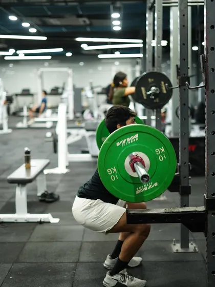 The squat is a cornerstone of strength. Here, a member demonstrates proper depth and form under load, building powerful legs and a strong core.