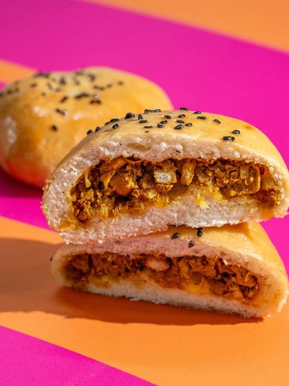 A close-up of the spiced chicken filling inside our soft, fluffy buns. This is pure comfort food, perfect for any time of day.