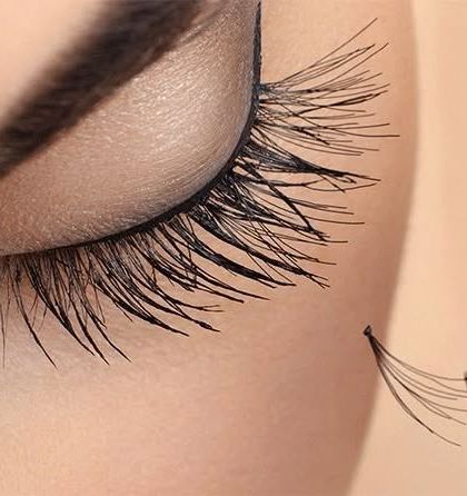 This macro image details our precision work. It shows a handmade lash fan just before it is applied to a single natural lash, which is the foundation of a beautiful volume set.