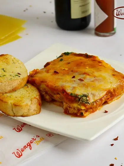 When you need something more than just a snack, our Chicken Lasagna is here for you. This image shows a hearty portion of our baked lasagna, layered with rich sauce, tender chicken, and melted cheese, served with a side of garlic bread. It’s a complete, comforting meal from our deli counter.