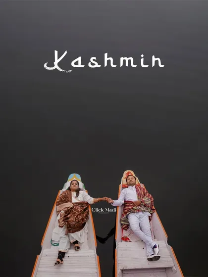 A creative top-down shot of the couple in traditional Kashmiri attire, holding hands in separate boats on Dal Lake. This artistic composition emphasizes their connection and the unique culture of the location.