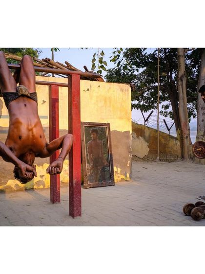 The color version of the gymnast at the outdoor gym. The red of the pull-up bar and the golden light of the sun add vibrancy to this display of strength.