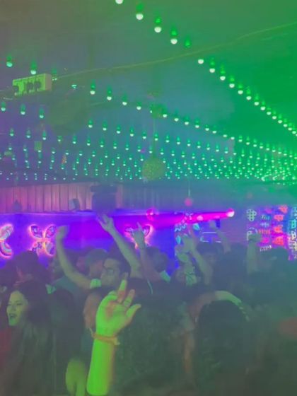 The green lights and packed crowd create a vibrant, high-energy scene.