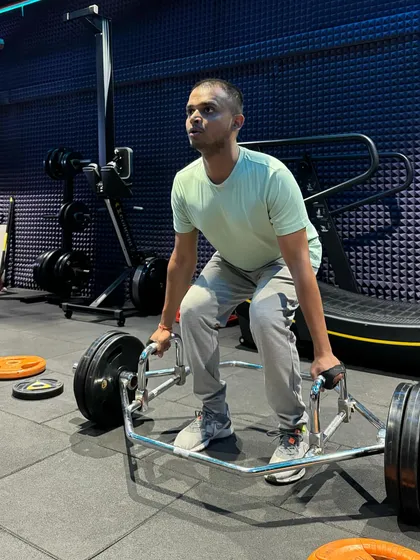 Here is the starting position for a trap bar deadlift. Notice how the client keeps his chest up and back flat, ready to drive through his legs to lift the weight. This form is crucial for a safe and powerful lift.