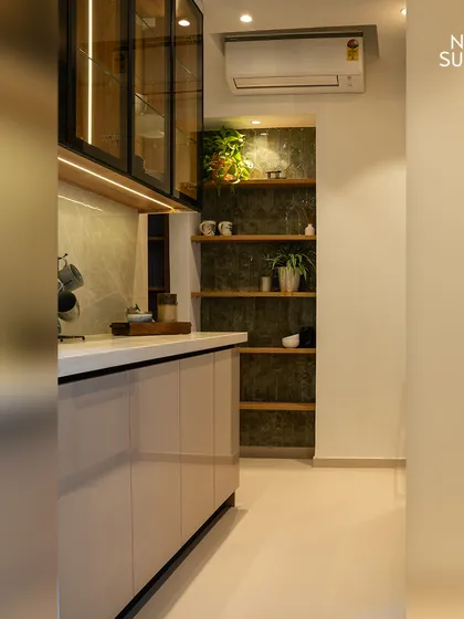 Another view showcasing the balance of open and closed storage. The glass-fronted cabinets with internal lighting offer a display opportunity, while the solid cabinets below conceal everyday necessities.