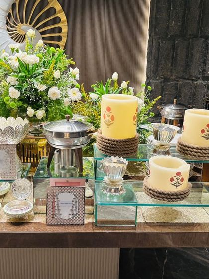 An elegant buffet setup featuring beautiful candles, silverware, and fresh floral arrangements. We work to ensure our food counters are an integral part of the event's overall aesthetic.