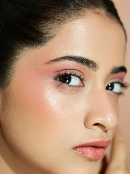 A close-up on the eye and cheek. The soft pink tones and the radiant highlight come together to create a dreamy, romantic look.