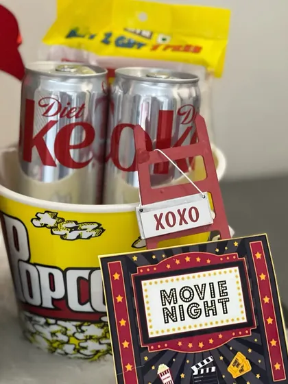 A close-up of our Netflix and Chill hamper, perfect for a cozy movie night. It includes a popcorn bucket, Diet Coke, and a movie night-themed card.