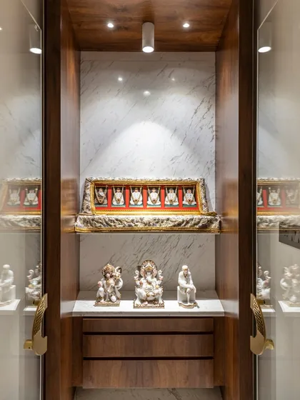 A closer look at the home temple in the Filigree House. Enclosed in glass and rich wood, this space is a beautifully lit sanctuary for idols and spiritual items, designed with reverence and care.