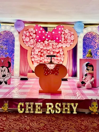 A creative and fun Minnie Mouse themed party for a second birthday. The centerpiece is a giant Minnie head silhouette filled with hundreds of pink balloons, creating a memorable photo opportunity.