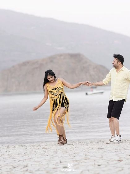 A joyful, movement-filled shot of the couple on the shores of the lake. This captures their energy and happiness in a natural way.
