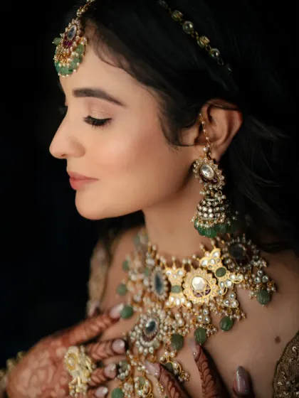 A close-up, profile shot of the bride, her eyes closed, highlighting her flawless makeup and stunning Polki jewelry.