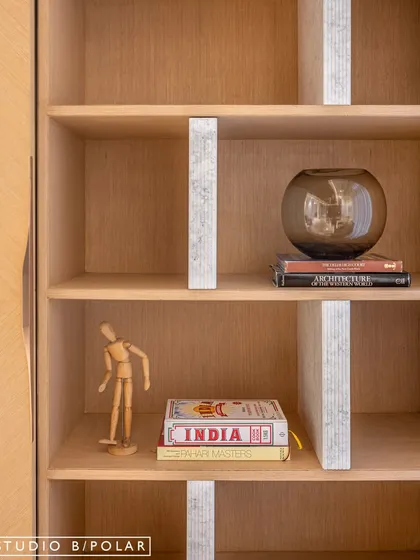 A close-up of the display unit, which is revealed when the sliding panels are closed. The light wood and subtle wallpaper inlay create an elegant and functional storage solution.