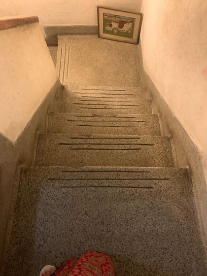 The original terrazzo staircase, with inlaid brass strips, a detail that is characteristic of the period and worth preserving.