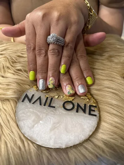 A bright and cheerful manicure perfect for summer. This set combines bold chartreuse nails with accent nails featuring hand-painted sunflowers and a sparkling silver glitter finish.