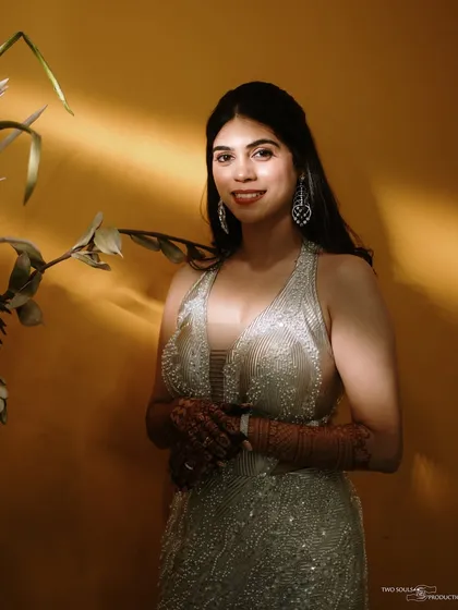 A glamorous solo portrait of the bride, with dramatic lighting highlighting her stunning silver gown and confident smile.