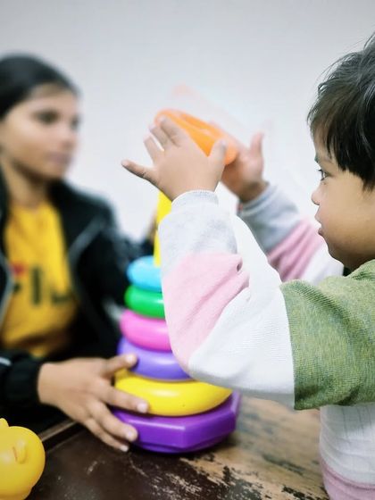 Stacking rings is a classic activity for a reason. During this speech therapy session, we use it to teach colors, sizes, counting, and turn taking, all while developing the child's fine motor skills.