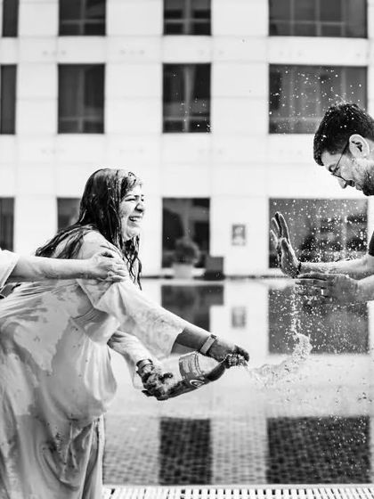 A candid black and white shot of guests having fun during the Haldi ceremony. The focus on their expressions and the chaotic energy makes this a powerful, story-driven image.