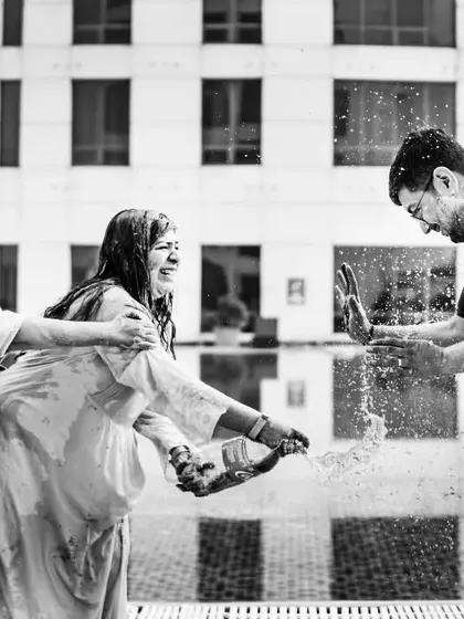 A candid black and white shot of guests having fun during the Haldi ceremony. The focus on their expressions and the chaotic energy makes this a powerful, story-driven image.