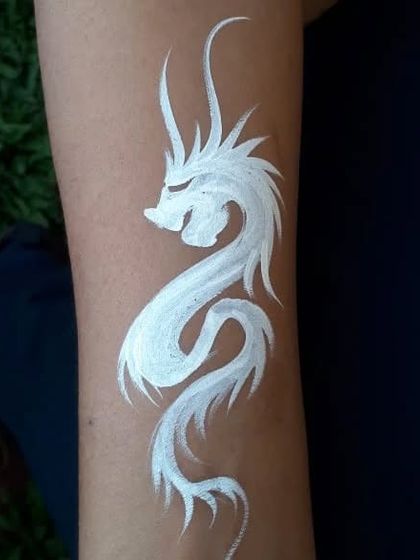 A striking white dragon temporary tattoo, painted on the arm.