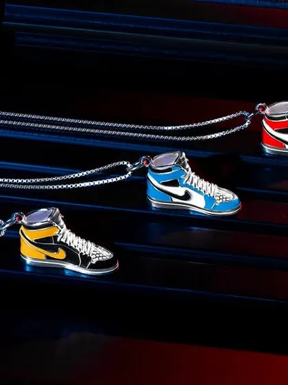 For this unique jewelry collection, we used colored gels to match the lighting to the colors of the sneaker pendants. This creative lighting technique makes the product details pop against the dark, textured background, creating a vibrant and edgy look.