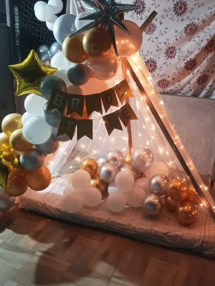 A full view of the terrace cabana setup, showing the balloon garland and star-shaped foil balloons.
