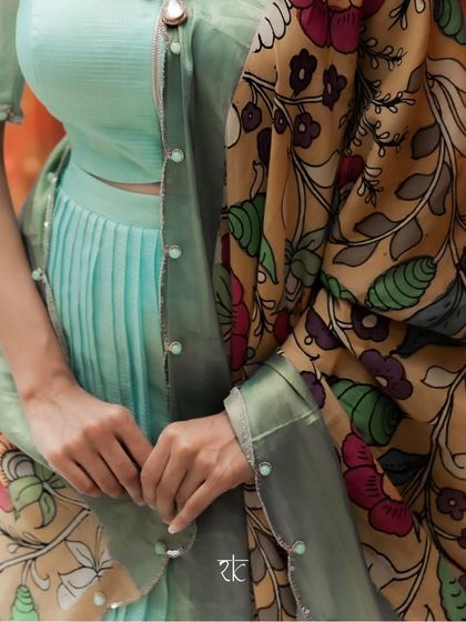 A detail shot showing the texture of the pleated chanderi silk and the intricate hand-painted design of the Kalamkari dupatta.