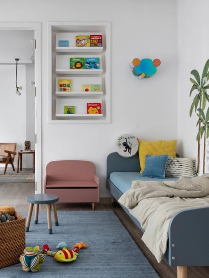 This kids' bedroom is designed for sleep, play, and adventure. The whimsical wall mural, playful furniture, and soft blue rug create a fun and imaginative space that can easily grow with the child.