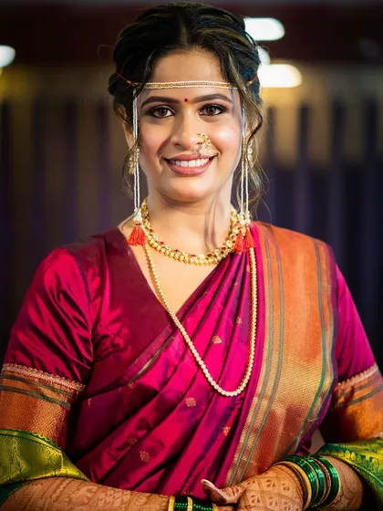 Embracing tradition with a touch of timeless beauty. This Maharashtrian bride in a deep pink saree radiates grace, with her makeup highlighting the classic *mundavalya* and *nath*.