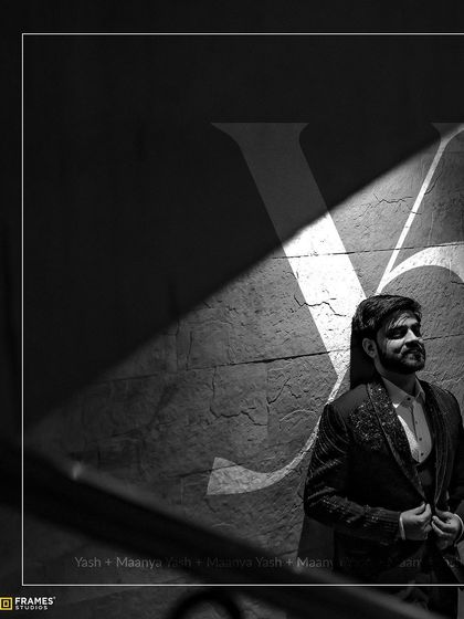 A powerful solo shot of the groom. The fit and fall of his embroidered suit are highlighted by the dramatic lighting.