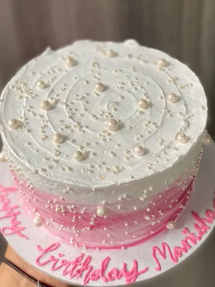 A top-down view of the beautifully sprinkled pink ombre cake.