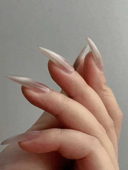 A side profile of the nude cat-eye nails, showing off the sharp stiletto shape and the way the light catches the magnetic polish.