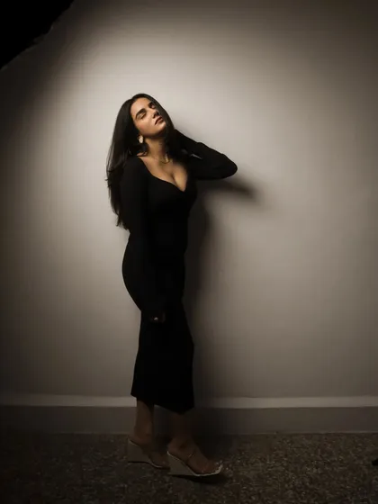 A studio session with a model in a black dress, showcasing a range of poses from pensive to powerful. The lighting is controlled to sculpt the subject and create a sophisticated mood.