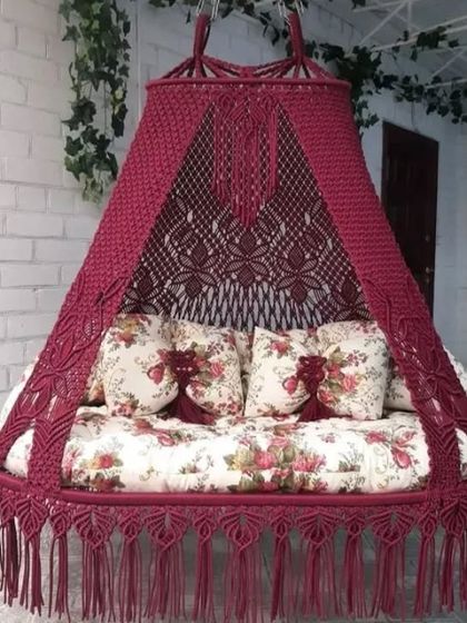 A beautiful maroon sofa swing with a floral mattress. This piece is perfect for adding a touch of traditional elegance and relaxation to your home.