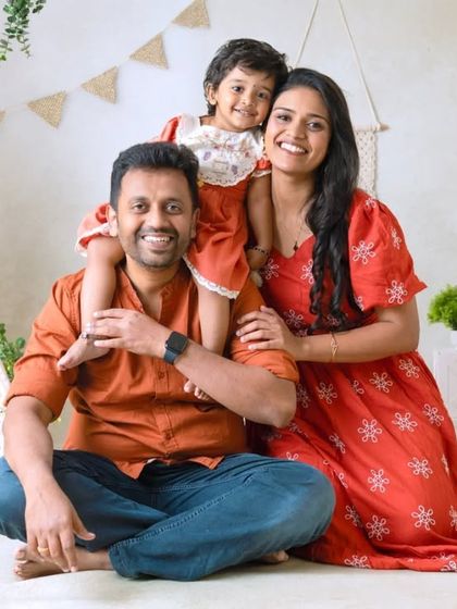 A beautiful family portrait in the boho-themed setting. The daughter on her father's shoulders adds a playful touch to this warm and rustic scene.
