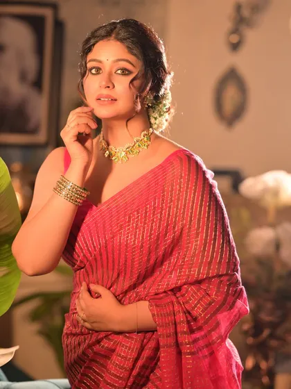 A classic portrait pose from the festive series. The composition includes a framed picture of Rabindranath Tagore in the background, adding a layer of cultural depth.