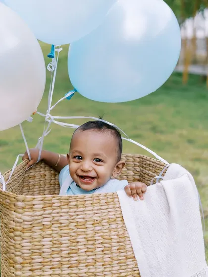 A big, happy smile from the birthday boy in his balloon basket. These are the moments that make a first birthday shoot so special.