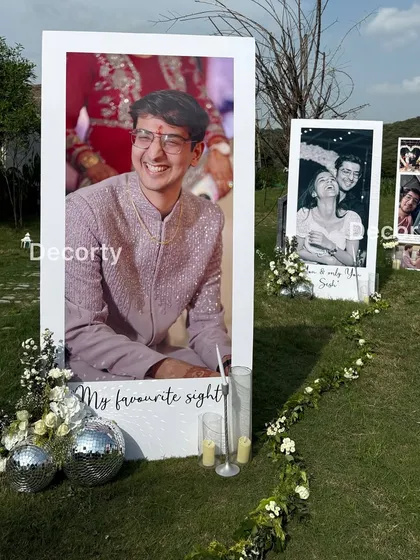 A close-up of the personalized photo displays for an outdoor proposal, featuring large portraits of the couple with handwritten captions.