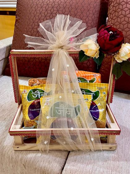 Even simple gifts can look special. Here, I've packed packets of traditional snacks in a wooden crate basket, wrapped in pearl-studded net to elevate it for a wedding ceremony.