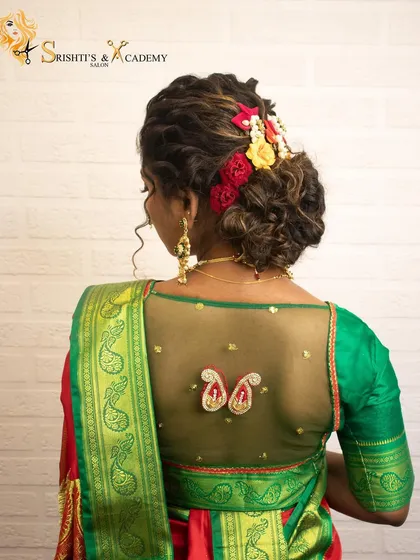 The back view of a Maharashtrian bridal look, showcasing a messy bun adorned with colorful flowers, perfectly complementing the traditional saree.