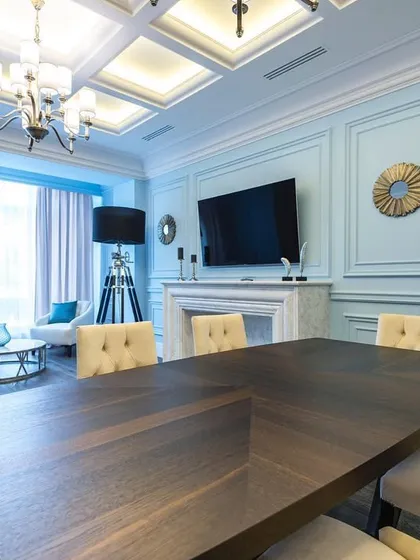 This multi-functional room serves as both a high-end dining area and a corporate boardroom. I used classic wall molding, a soft blue color palette, and a statement dining table to create a space that is formal yet inviting.