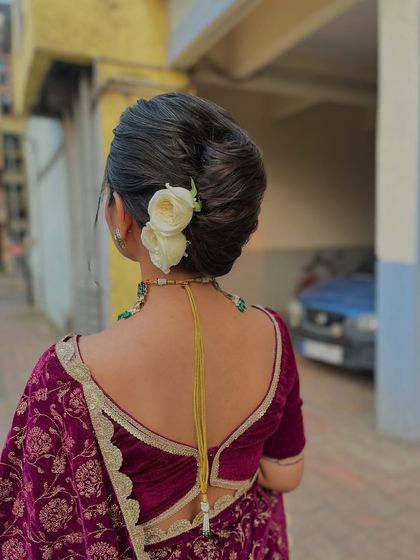 This clean, classic bridal bun is adorned with simple white roses. It's an understated and elegant take on the traditional khopa, ideal for a bride who prefers a minimalist yet timeless look for her wedding day.
