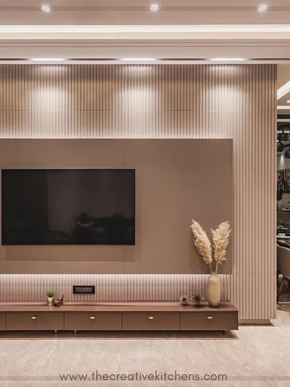 Detail is paramount in our designs. This image highlights the clean lines and flawless PU finish of the modular TV unit, set against a textured fluted panel wall. The warm, downward-facing spotlights enhance the unit's form and create a sophisticated focal point.